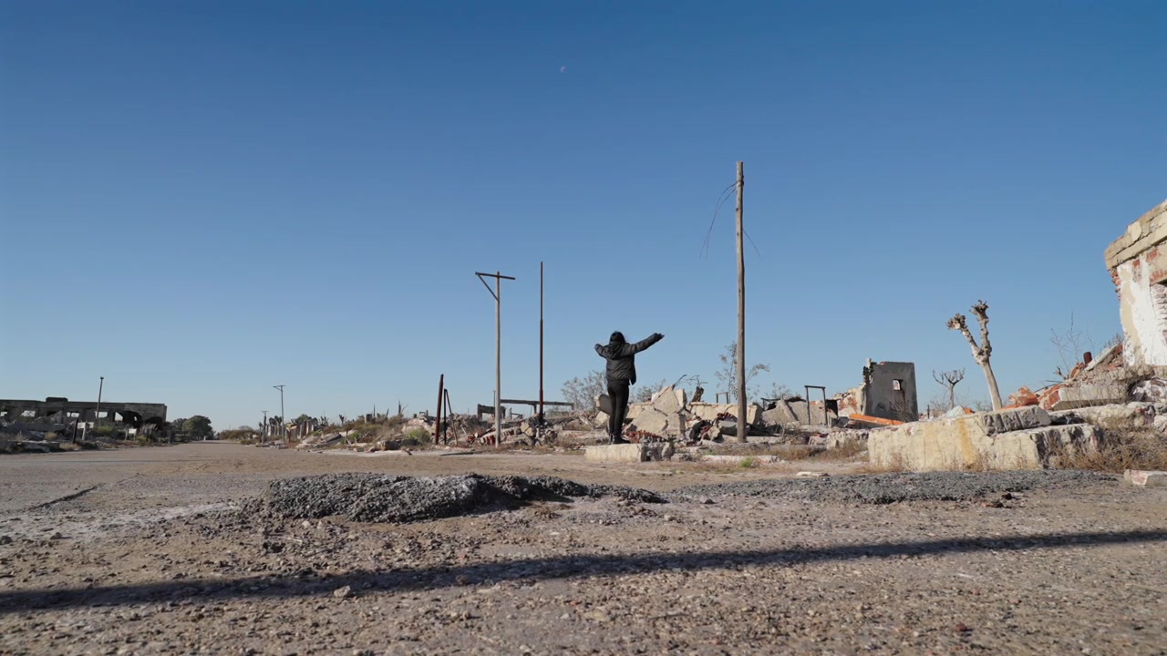Una figura solitaria si erge tra le macerie di una città demolita, catturando l'essenza della solitudine e della disperazione post-apocalittica. Utile per documentari sul cambiamento climatico o sulla guerra
