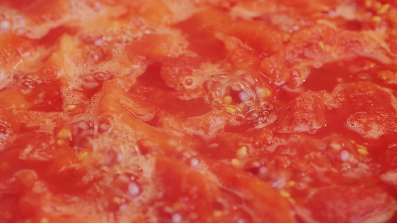 Cooking fresh peeled canned tomato Juice sauce in pan, peeled tomatoes boiling in their own juice, making tomatoes pasta sauce .Top view close up, Italian traditional cuisine food.