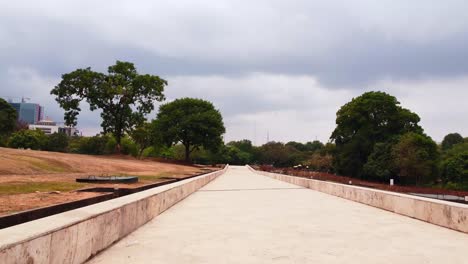 drone glides over scenic path in abuja’s millennium park, lush with urban nature