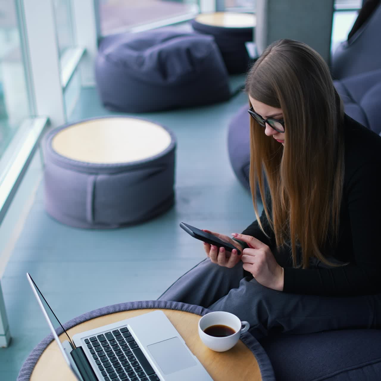 Beautiful young woman working on laptop computer while drinking coffee
