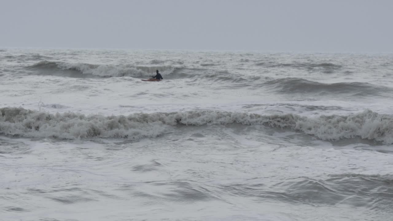 폭풍우 치는 바다에서 카약을 타는 남자
