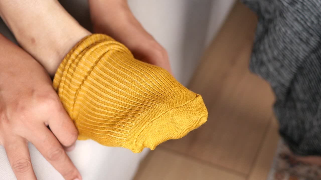 женщина надевает желтые носки.