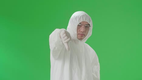 asian male wearing personal protective equipment uniform ppe and showing thumbs down, unlike in green screen studio