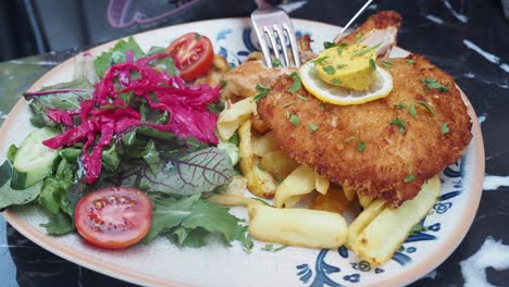 breaded chicken cutlet with french fries and salad