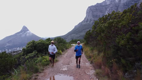 two senior men running on a mountain trail