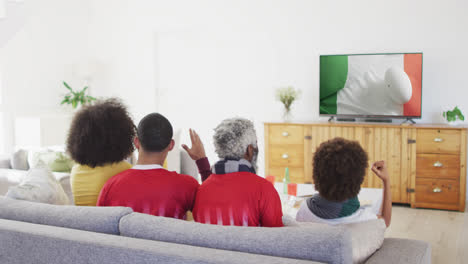 Biracial-Familie-Vor-Dem-Fernseher-Mit-Rugbyball-Auf-Der-Flagge-Der-Elfenbeinküste-Auf-Dem-Bildschirm