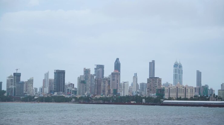 Tomada panorâmica de edifícios e arranha-céus do horizonte de Mumbai com o oceano à frente em um dia nublado de monções