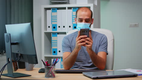 Office-worker-with-mask-using-phone