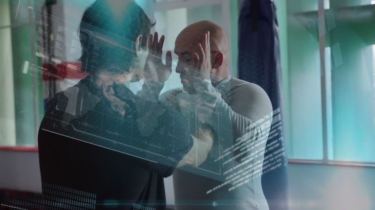 Training partners doing blocking drills in fitness gym showing punching bag and holographic overlay