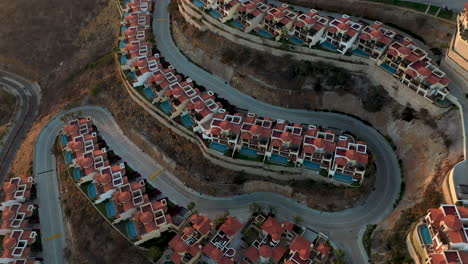 Cinematic-drone-shot-of-resort-villas-then-revealing-the-city-behind-them-in-Cabo-Lucas-Mexico