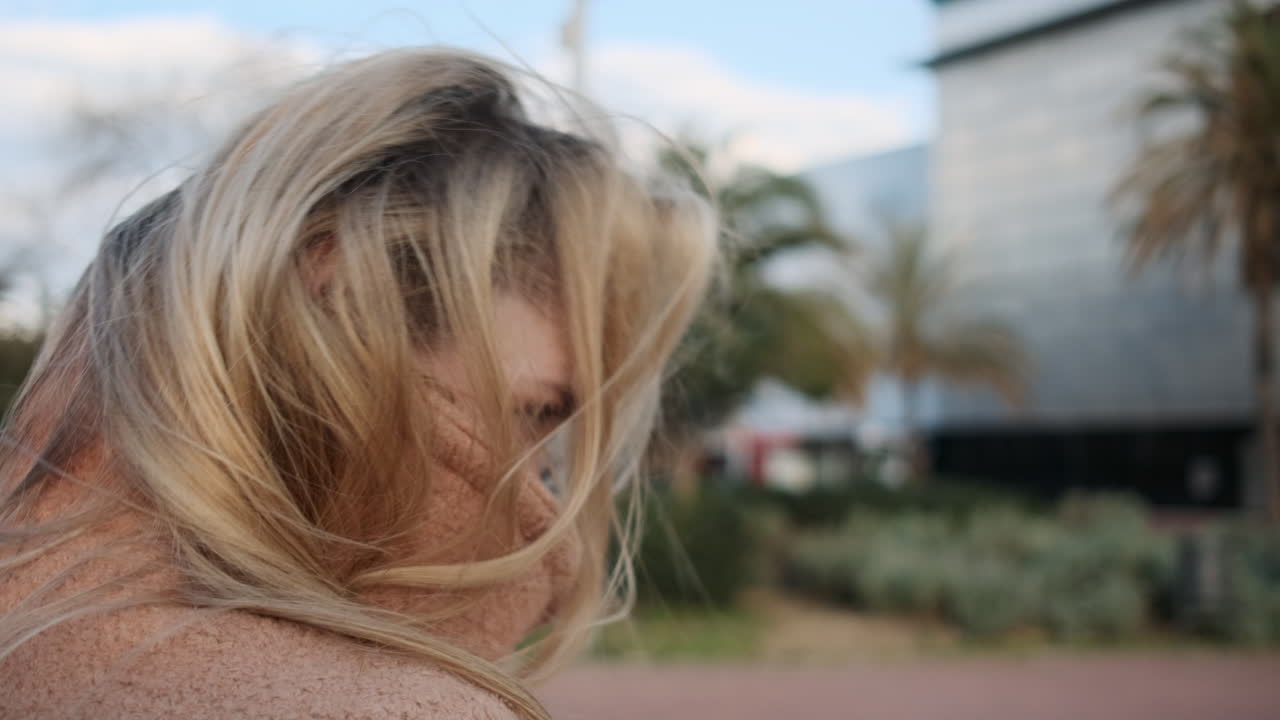 코트로 얼굴을 고 있는 젊은 여성.