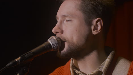 close up of male musician talking into microphone before live music perfomance