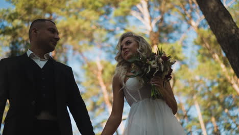 family of man in suit and pretty woman walks along park