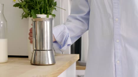 parte de una mujer haciendo café en su cocina