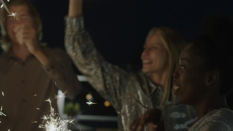 amigos celebrando con sparkler por la noche