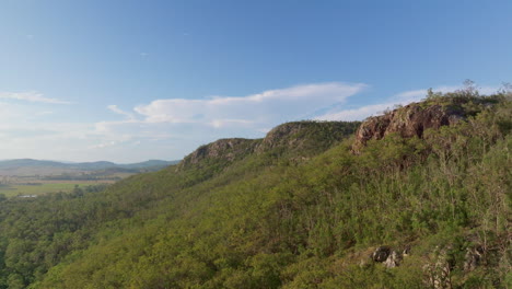 Drohnenansicht-Eines-Felsbrockens,-Der-An-Einem-Sonnigen-Tag-Aus-Dem-Berggipfel-Ragt,-4k-Queensland,-Australien