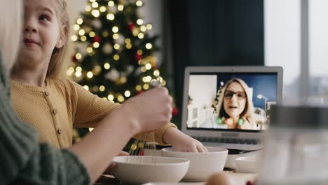 Mother-and-daughter-during-video-conversation-with-grandma-in-kitchen