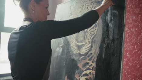 woman painting a leopard portrait