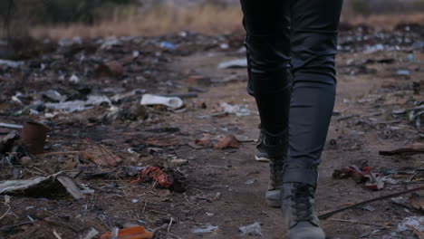 close-up of women's feet walking through dumpsite