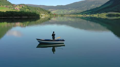 Una-Mujer-En-El-Barco-Pesca-Un-Pez-Girando-En-Noruega.