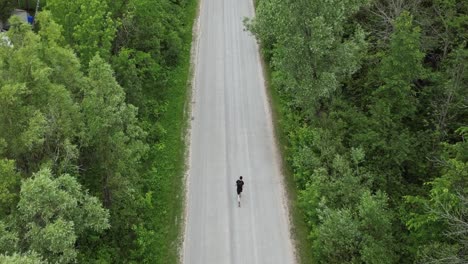 top view of a man running across the empty country road