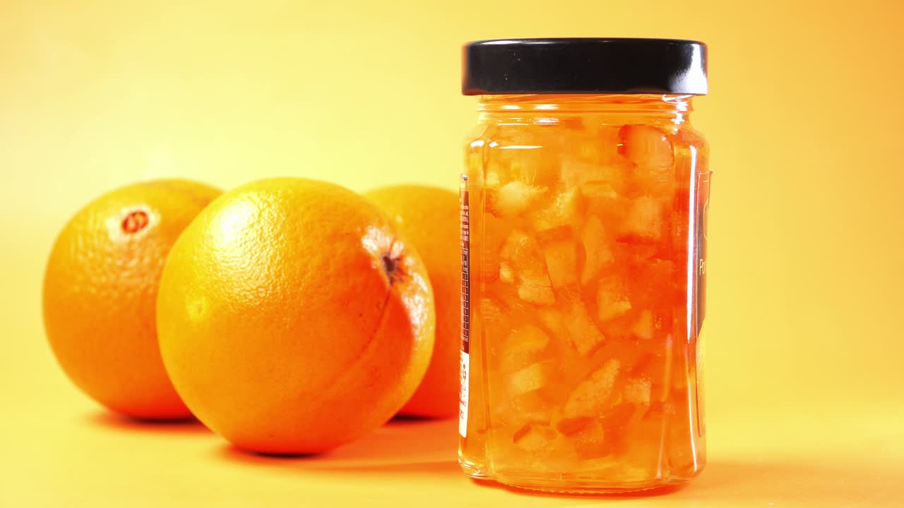 frasco de mermelada de naranja con naranjas frescas