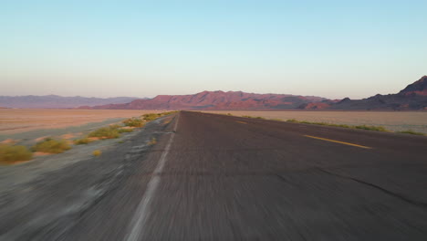 driving on empty road by bonneville salt flats and speedway fileds in utah usa