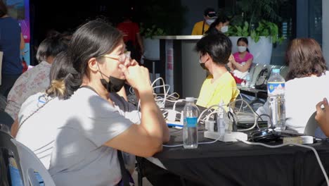 Close up of asian Woman calling family in shopping center after losing home during natural disaster at night