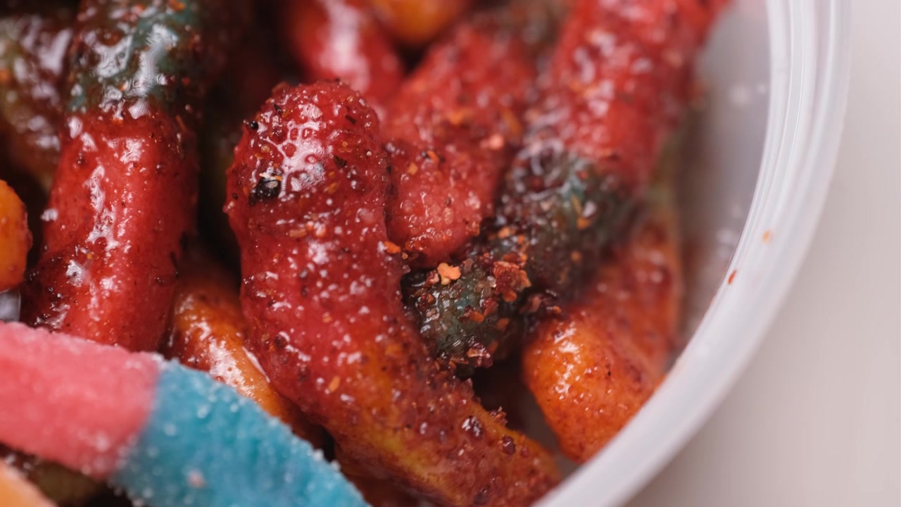 Macro de minhocas de goma com pimenta chamoy girando em uma bandeja giratória