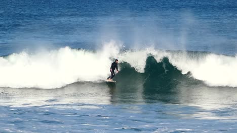 young man teen surfer surfing tropical ocean wave attacking off the lip in cascais surf spot