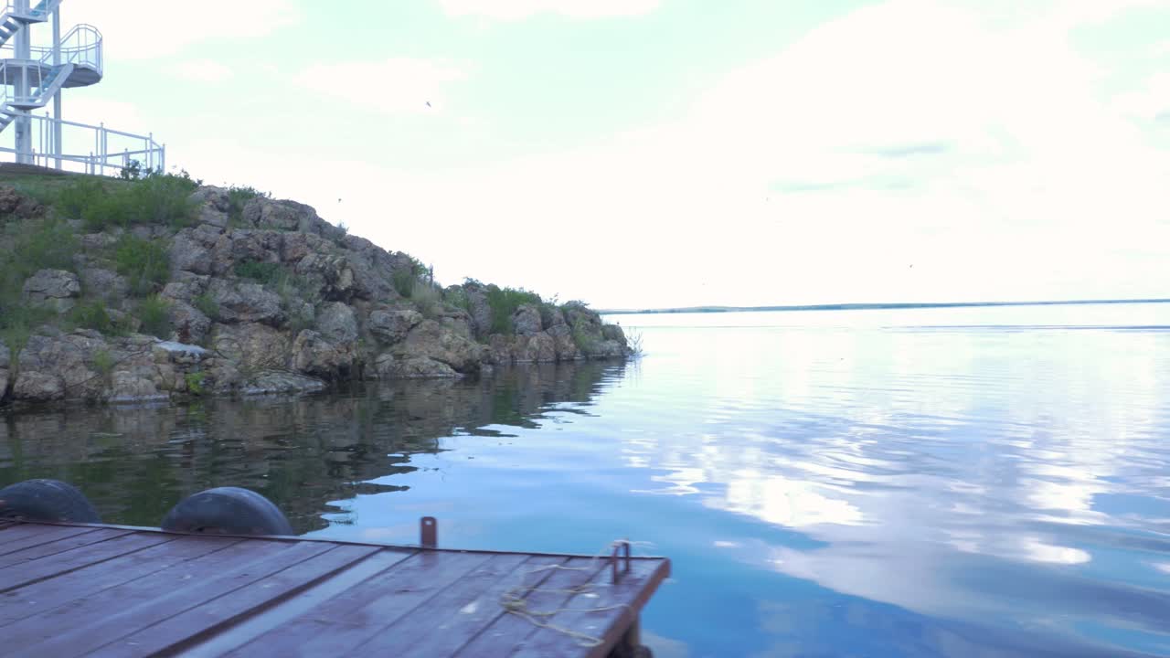 Pemandangan Tepi Danau dengan Bebatuan dan Dermaga