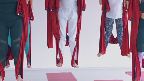 women-legs-stand-on-red-anti-gravity-yoga-hammocks-cloth