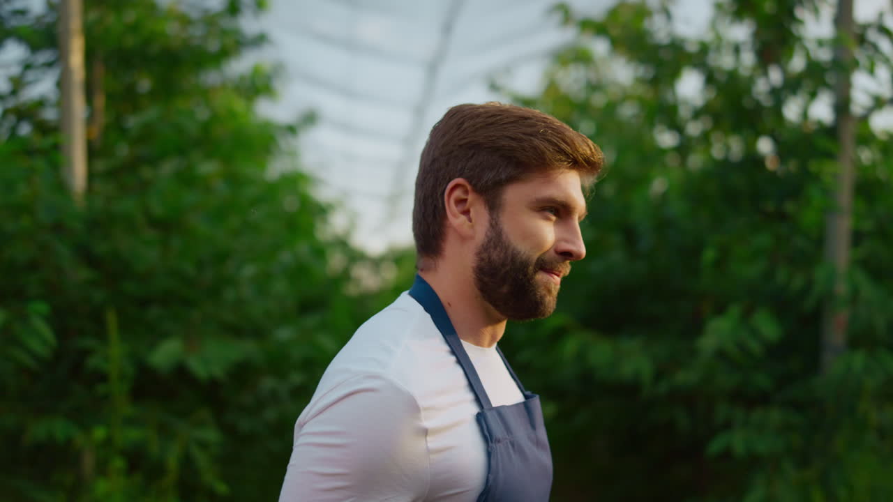 인간 농학자는 생태적 수확 정원 플랜테이션 현대적인 집에서 재배를 점검합니다.