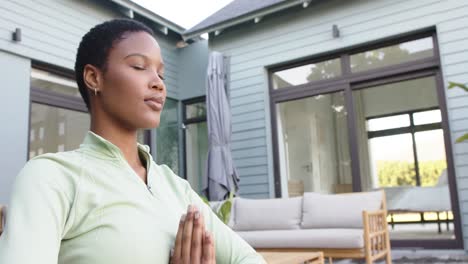 Fokussierte-Biraziale-Frau,-Die-Yoga-Praktiziert-Und-Im-Garten-Meditiert,-Zeitlupe