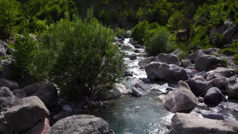 el agua del arroyo fluye sobre piedras pulidas que caen desde las altas montañas en los alpes albaneses