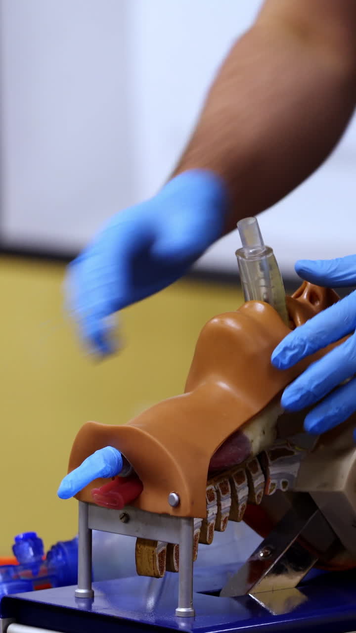 Training course on dummy head. Practitioner in medical gloves performing a resuscitation procedure on a manikin. Practical skills. Vertical video