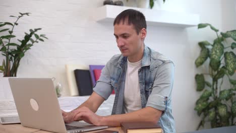 businessman working on laptop computer at home office. male professional typing on laptop keyboard at office workplace. portrait of business man looking at laptop screen indoors