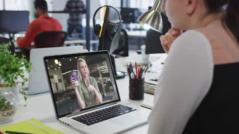 Kaukasische-Frau,-Die-Im-Büro-Einen-Videoanruf-Mit-Einer-Kollegin-Auf-Einem-Laptop-Führt