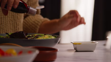 가정에서 부에서 건강한 채식주의자 또는 채식주의자의 식사를 준비하는 여성의 근접 사진, 러드 잎의 그에 드레싱을 부어 1
