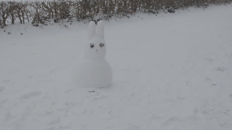 Dolly-in-of-bunny-shaped-snow-man-in-winter