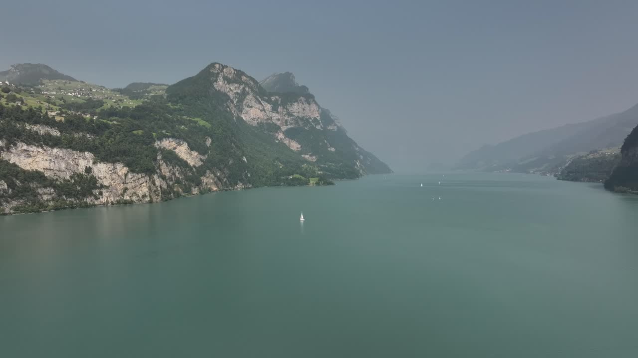 Scenic Lake Landscape with Mountains and Sailboat