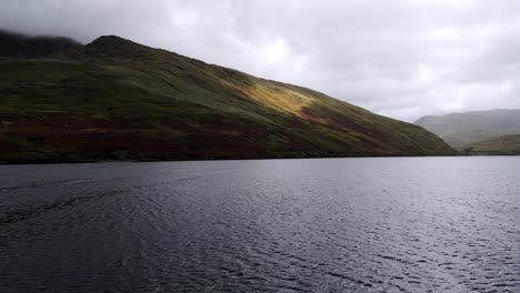 Drohnenflug-über-Einen-Großen-See-Oder-Loch-Im-Schottischen-Hochland-Mit-Sanften-Grünen-Bergen-Und-Einer-Straße,-Die-Der-Küstenlinie-Folgt