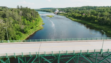 High-Aerial-Shot-Flies-Over-Bridge-with-Hydroelectric-Dam-and-Power-Plant-in-the-Background,-Maine-USA