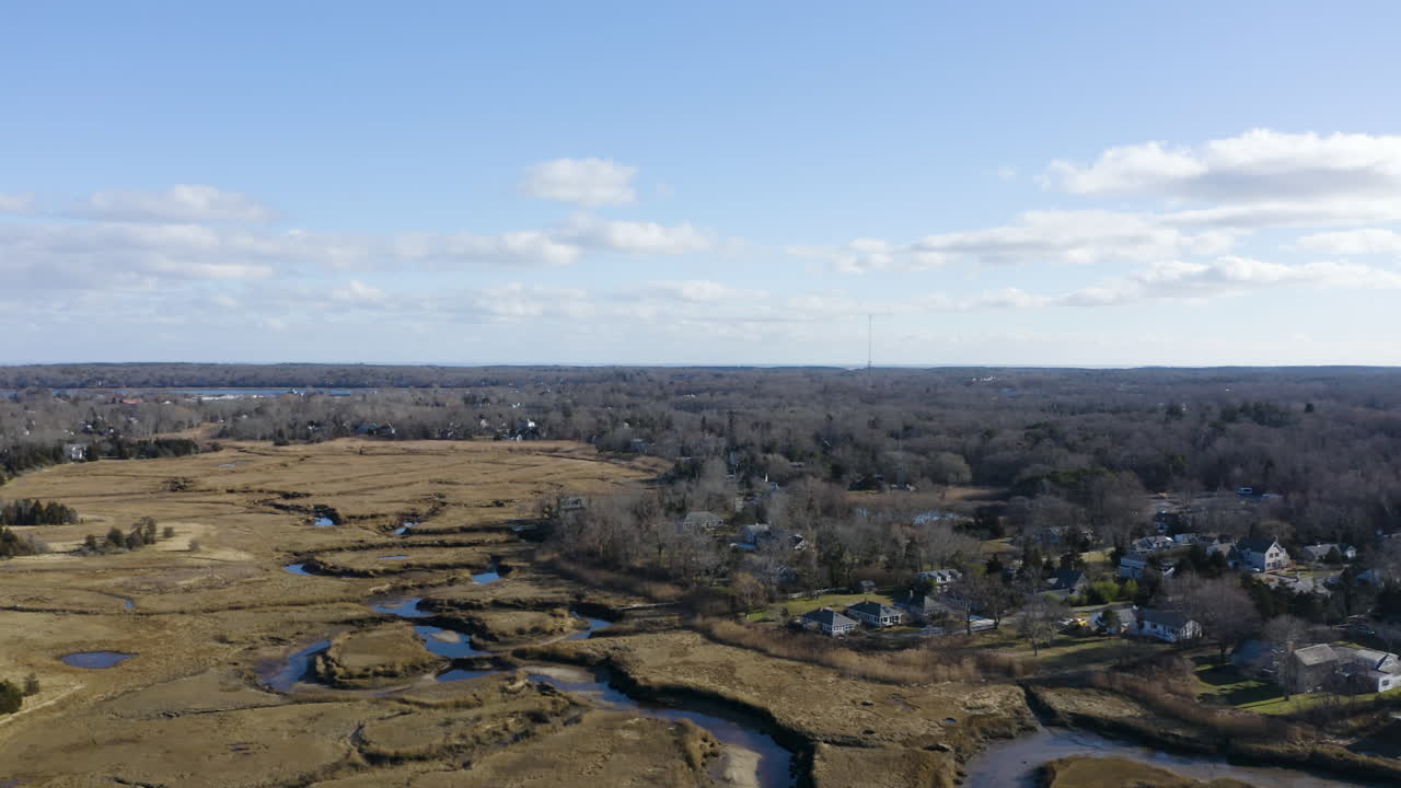 The camera moves right to reveal Rock Harbor Creek. This is a marsh with a small creek running through it that feeds water into the Rock Harbor marina. There are many small tide pools in the marsh.