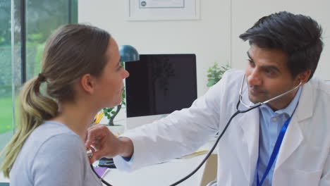 médico masculino o médico de cabecera examinando a una adolescente escuchando los latidos del corazón con un estetoscopio