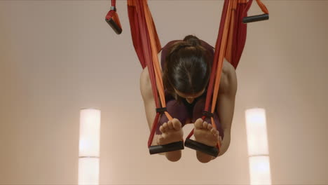 chica practicando yoga antigravedad en el estudio. mujer estirando el cuerpo en hamaca