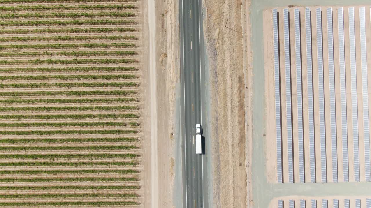 오른쪽의 태양 전지판과 왼쪽의 포도밭으로 둘러싸인 지방 시골길을 내려다보는 고지대 조감도