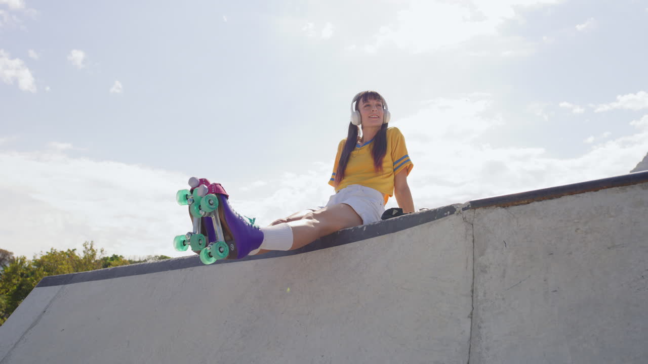 Trendy young roller skater girl listening to music