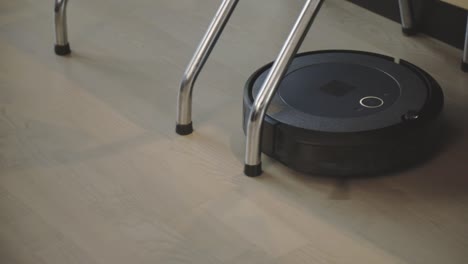 un robot aspirador está realizando el mantenimiento del piso - de cerca