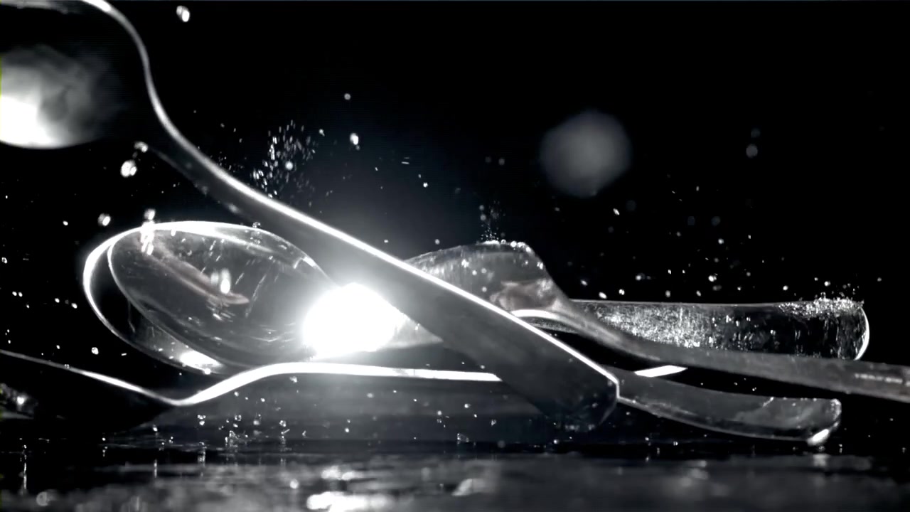 Slow Motion Cutlery Falling and Splashing on a Wet Black Surface
